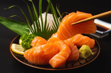 Sashimi, somon, Japon yemek çubukları ve ahşap masada wasabi.