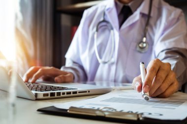 Tıbbi teknoloji konsepti. Doktor cep telefonu, steteskop ve dijital tablet dizüstü bilgisayarla sabah saatlerinde modern hastanede çalışıyor.