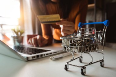 Online alışveriş sepeti kavramı. akıllı telefon, tablet ödemeler ve holding kredi kartı online alışveriş, omni kanal, bilgisayar sanal simgeler kullanarak iş kadını ele 