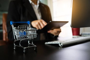 Online alışveriş sepeti kavramı. akıllı telefon, tablet ödemeler ve holding kredi kartı online alışveriş, omni kanal, bilgisayar sanal simgeler kullanarak iş kadını ele 
