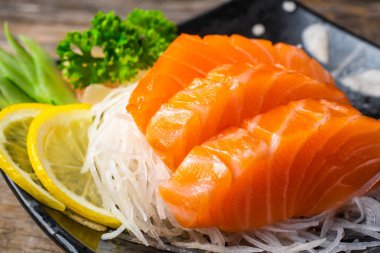 Sashimi, somon, Japon yemek çubukları ve ahşap masada wasabi.