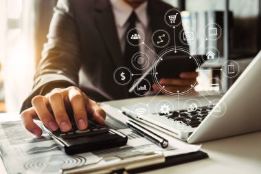 Maliyet, hesap makinesi ve tabletli dizüstü bilgisayarla ilgili finansman ile çalışan işadamı elleri, sabah saatlerinde ofiste akıllı telefon.