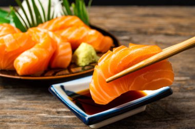 Sashimi, somon, Japon yemek çubukları ve ahşap masada wasabi.