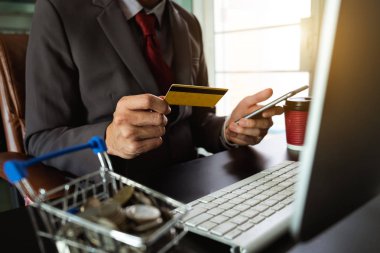 işadamı el akıllı telefon, tablet ödemeler ve holding kredi kartı kullanma online alışveriş, omni kanal, dijital tablet klavye bilgisayar Bürosu'nda güneş ışığı yerleştirme