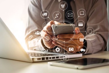 Sabah ışığında ofiste VR simge diyagramı ile dizüstü bilgisayar ve dijital tablet bilgisayar ile modern ofiste cep telefonu kullanarak adam eller