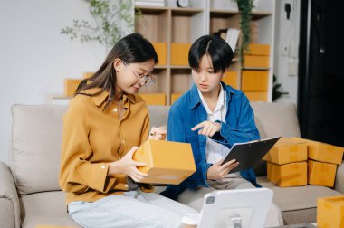 Küçük işletmeler kurmak KOBİ sahipleri, online siparişleri kontrol edin. Kanepede, ev işlerinde kutularla çalışan ürünler satmak. 