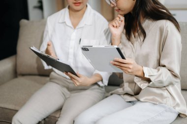 Modern ofiste genç iş adamlarının koltukta birlikte çalışmasının portresi. Çift çalışması başlangıç konsepti