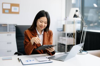 Ofis masasında dizüstü bilgisayar kullanan bir iş kadını. Ofiste vergi, rapor, muhasebe, istatistik ve analitik araştırma kavramı 