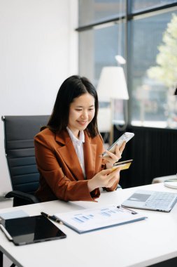 Ofiste kredi kartı ve akıllı telefon kullanan bir girişimci. 