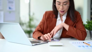 Masada otururken akıllı telefon kullanan profesyonel bir kadın.