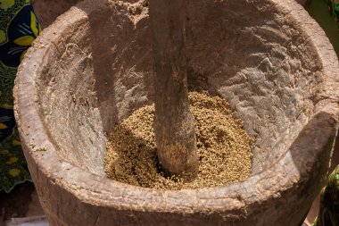 Bir Afrika geleneksel ahşap harç ve havaneli, Burkina Faso ile kırma tahıllar.