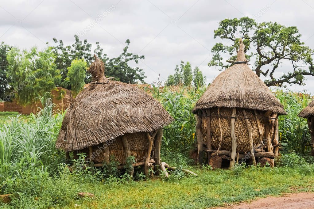 Two traditional african granaries made of wood and straw, suburb of Ouagadougou, Burkina Faso.
