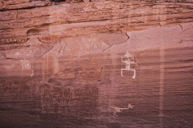 Kanyon de Chelly ulusal anıt bir insanımsı ve bir hayvan, Arizona, ABD temsil eden bir kumtaşı cliff oyma Anasazi petroglifler.