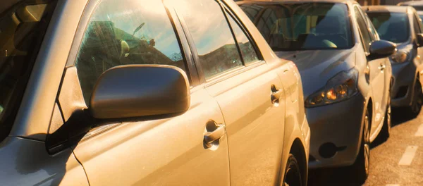 Some parked cars with the sun shining on them, transportation concept.