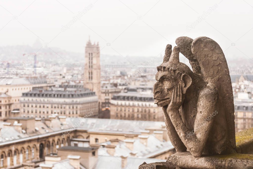 Stone sculpture of chimera of the Notre-Dame of Paris cathedral, France, with bright copy space.