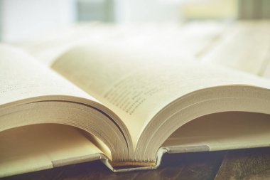 Güzel yüksek anahtar closeup ahşap bir masa üzerinde beyaz sayfalar ile açık bir kitap. Okuma ve okuma-yazma kavramı.