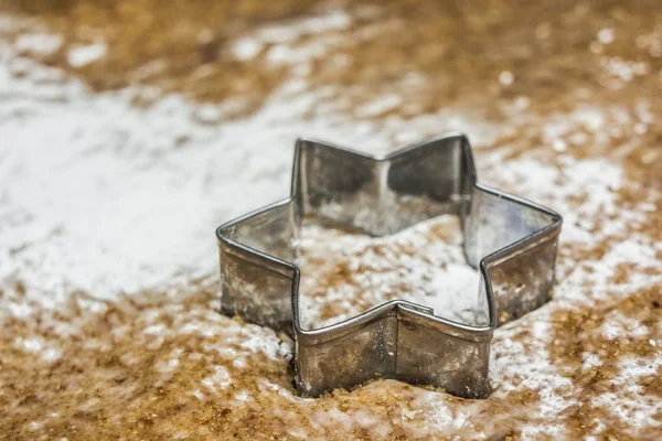 A star shaped pastry cutter on a pastry ready to make traditional christmas cookies - Alsace, France.