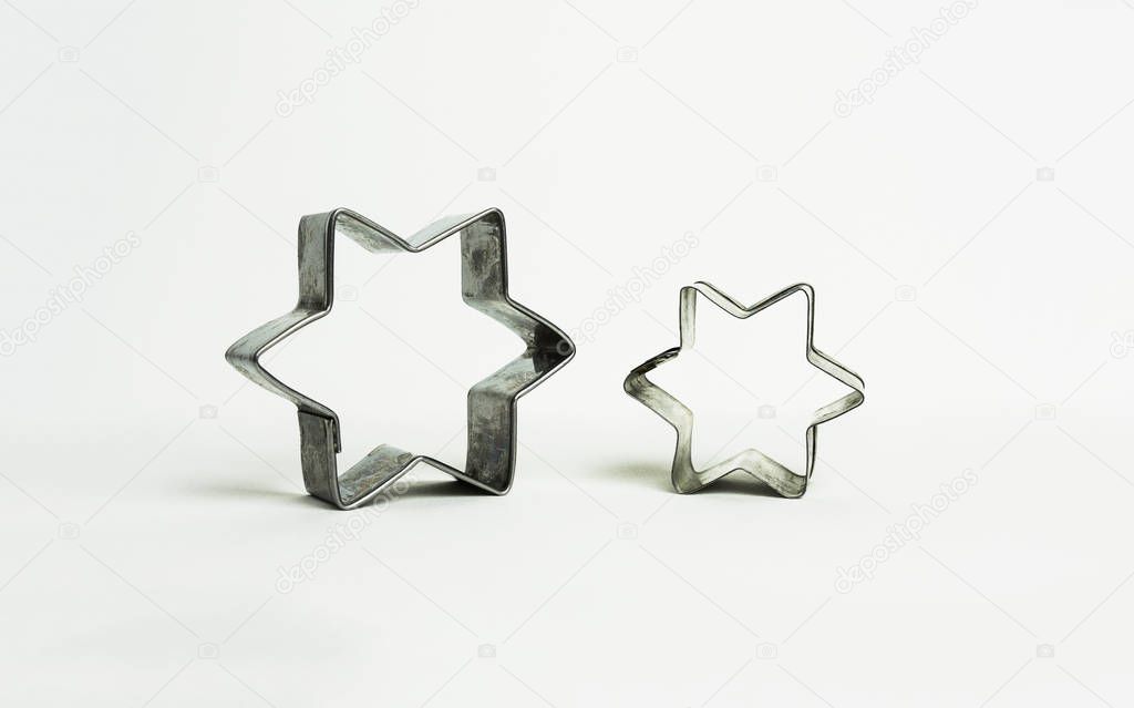 Two star shaped pastry cutters used to make traditional christmas cookies - white background - Alsace, France.