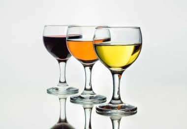 Üç bardak şarap ayna yansıması ile beyaz arka plan üzerinde izole.