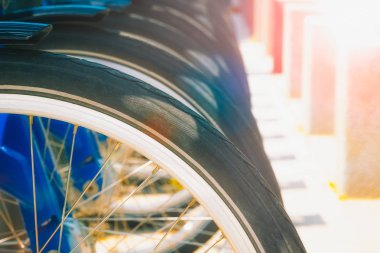 Park halindeki bisiklet lerin veya bisikletlerin tekerleklerinin sırası güneş parlamaları ve kopya alanı ile.