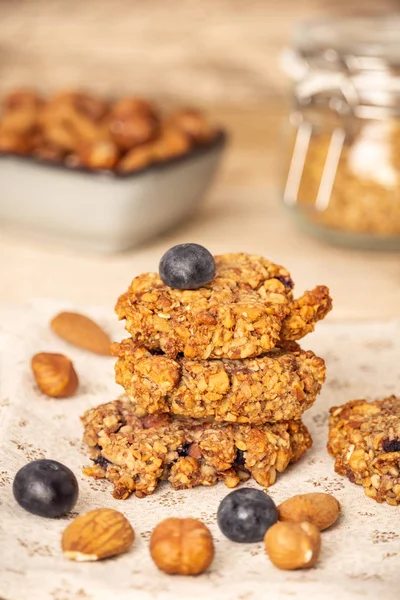 Homemade oat bran cookies with blueberries, hazelnuts, almonds, and walnuts. Healthy food. Vertical composition.
