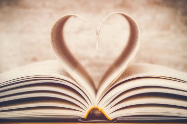 Kalp şekli, kitap sayfalarının yakından çekilmesiyle oluşmuş. Tonlanmış ve rüya gibi bir görüntü.