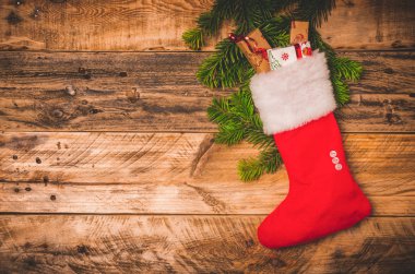 Beyaz kürklü Noel kırmızı çorabı ve ahşap bir arka planda hediyeler. Fotokopi alanı ile düz ya da üstteki görüntü.
