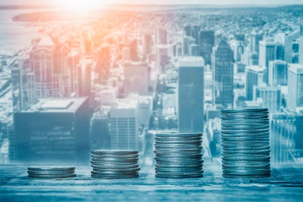 Şehir manzaralı ya da arka planda ufuk çizgisi olan bozuk paralar. Finansal büyüme, emlak sektörü fiyatları, belediye bütçesi veya şehir fonları, ekonomi veya bankacılık kavramları.