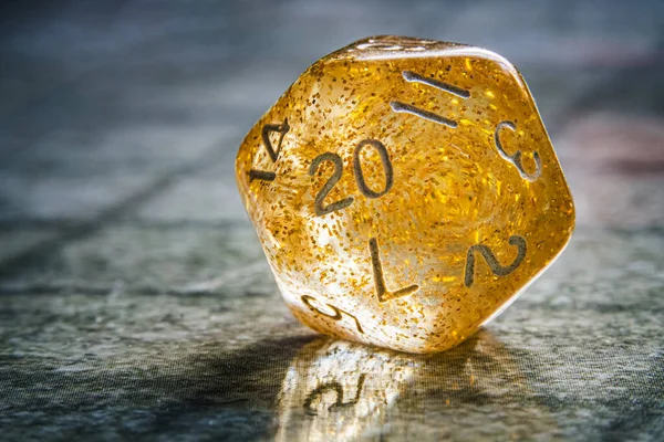 Yellow role playing game 20 or twenty sided dice close-up. Board game and rpg concept with copy space