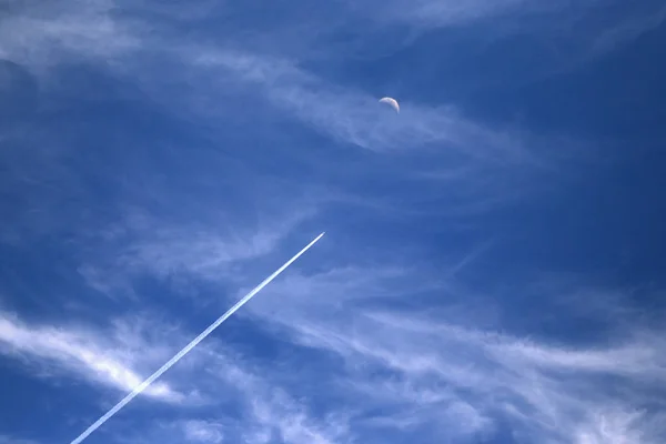 airplane leaving a trail  flies to the moon.