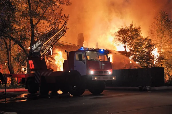 有梯子和两个蓝色闪光灯的消防车 房子的消防背景 — 图库照片