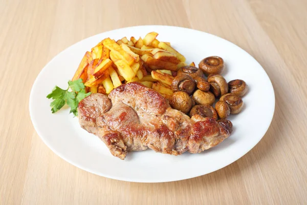 Bife com batatas fritas e cogumelos vista lateral — Fotografia de Stock