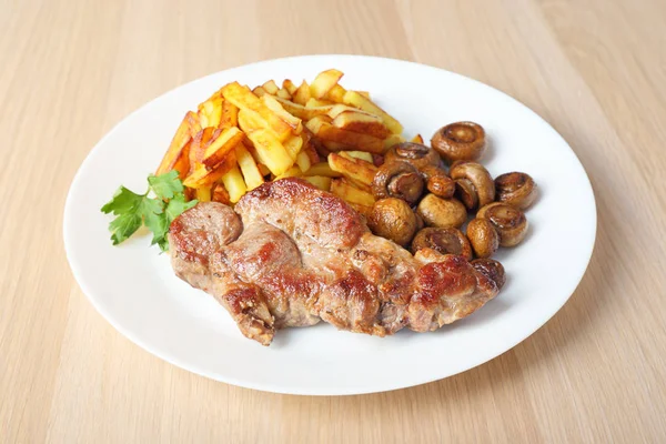 Steak with fried potatoes and mushrooms side view — Stock Photo, Image