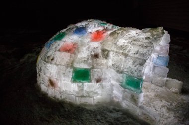 Rastgele renk igloo, karanlık bir arka plan üzerinde içeriden aydınlatılmış. 