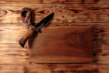 Çelik ve ahşap saptan el yapımı av bıçağı. Eski ahşap arka planda şık bıçak.