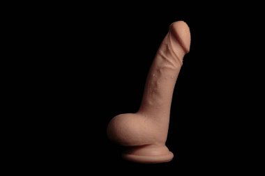 Wet realistic dildo isolated on black