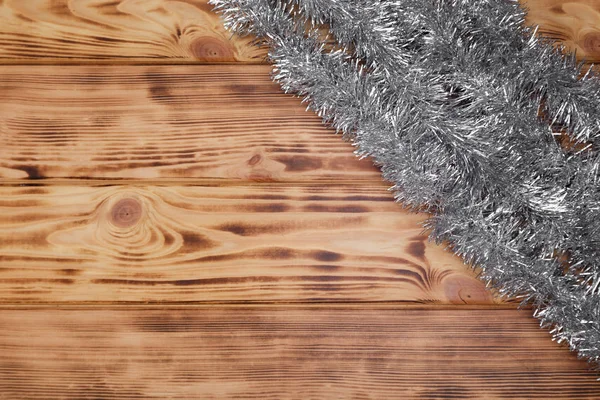 Vánoční rustikální pozadí-hobliny na dřevě s tinselem a volným textovým prostorem — Stock fotografie