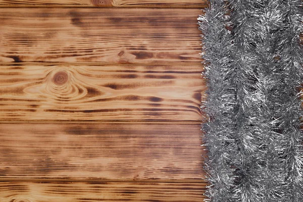 Vánoční rustikální pozadí-hobliny na dřevě s tinselem a volným textovým prostorem — Stock fotografie