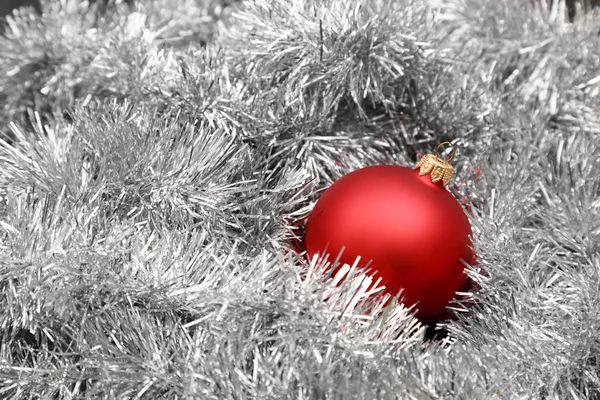 Bola roja de Navidad en oropel de plata — Foto de Stock