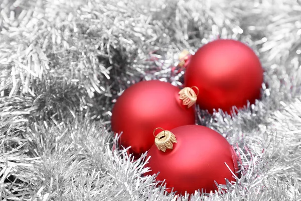 Rudé vánoční koule na stříbrném tinselu — Stock fotografie