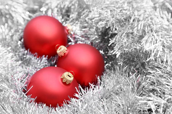 Rudé vánoční koule na stříbrném tinselu — Stock fotografie
