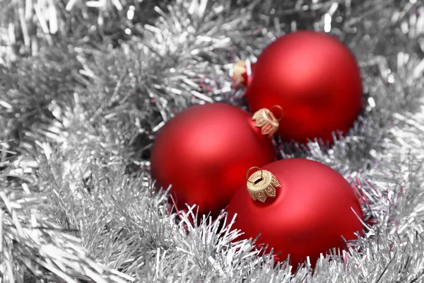 Красные рождественские шары на серебряной мишуре — стоковое фото