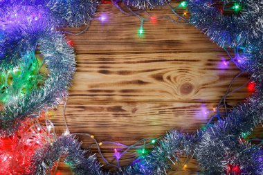 Ahşap arka planda Noel ışıkları ve tinsel