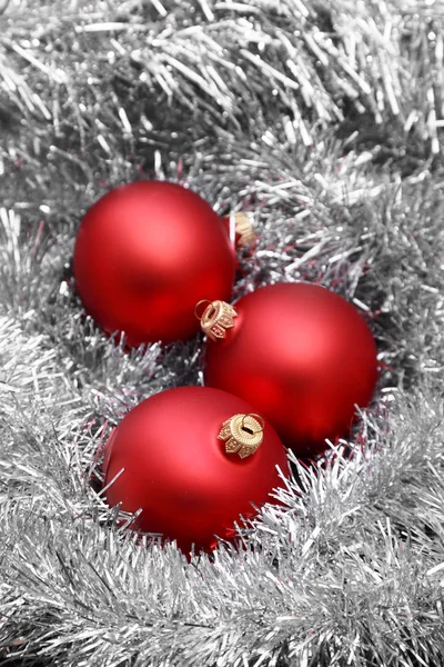 Rode kerstballen op zilver klatergoud — Stockfoto