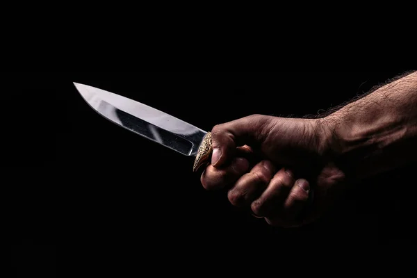 Hunting knife in hand on dark background — Stock Photo, Image