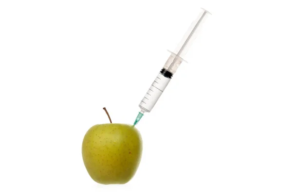 Seringa com líquido incolor preso em uma maçã isolada em branco . — Fotografia de Stock