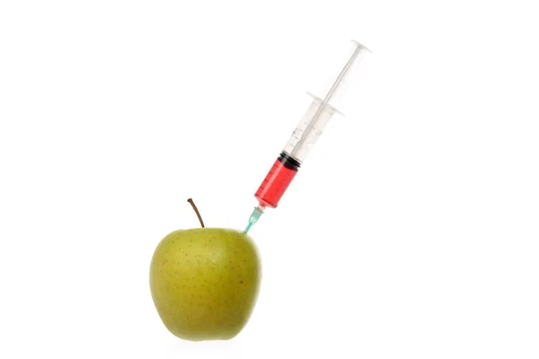 Seringa com líquido colorido preso em uma maçã isolada em branco . — Fotografia de Stock