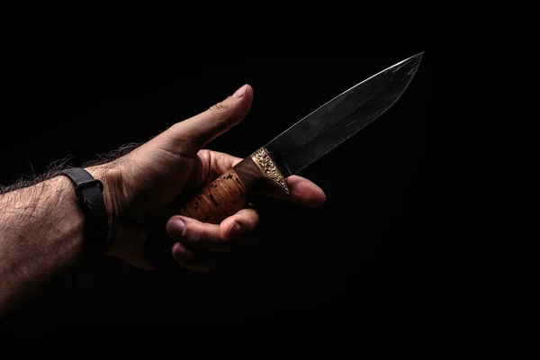 Охотничий нож в руке на темном фоне — стоковое фото