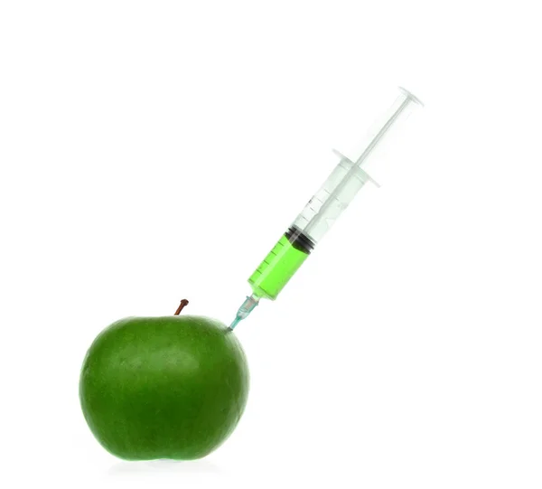 白で隔離されたリンゴに着色された液体が刺さった注射器. — ストック写真