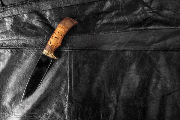 Siyah deri arka plan üzerinde avcılık bıçağı — Stok fotoğraf